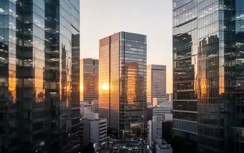 Moderne Skyline eines japanischen Finanzviertels bei Dämmerung mit spiegelnden Bürogebäuden. - Foto: über boerse-global.de