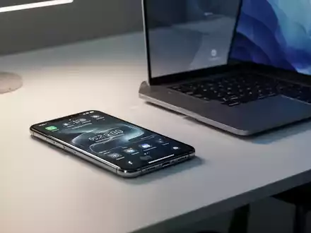 Moderner Arbeitsplatz mit Smartphone und Laptop, der Apples neue KI-Abonnementdienste repräsentiert. - Foto: über boerse-global.de