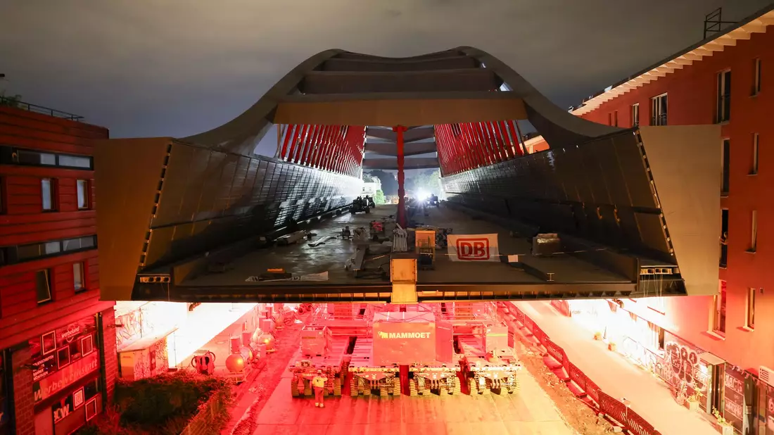 Ein Fahrzeug mit 1.088 Rädern schiebt die neue Brücke Zentimeter für Zentimeter zu der Kreuzung, über die die Brücke künftig führen wird. - Bild: Christian Charisius/dpa