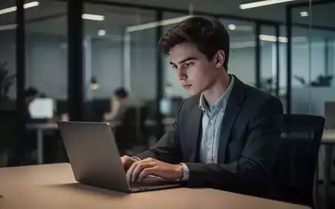 Ein junger Berufstätiger arbeitet an einem Laptop in einem modernen Büro, was die Unsicherheit am Arbeitsmarkt symbolisiert. - Foto: über boerse-global.de