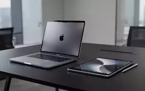 Ein Apple MacBook und ein iPad auf einem minimalistischen Schreibtisch in einer professionellen Büroumgebung. - Foto: über boerse-global.de
