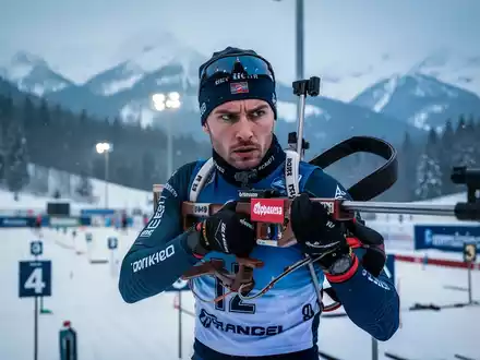 Eine Biathletin bei der Konzentration am Schießstand in einer verschneiten Winterlandschaft. - Foto: über boerse-global.de