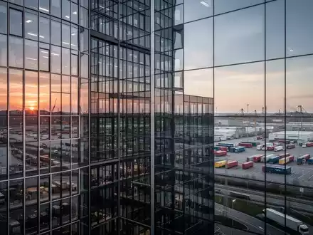 Modernes Bürogebäude vor einer Industrieanlage mit Logistikinfrastruktur zur Veranschaulichung der deutschen Wirtschaft. - Foto: über boerse-global.de