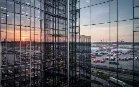 Modernes Bürogebäude vor einer Industrieanlage mit Logistikinfrastruktur zur Veranschaulichung der deutschen Wirtschaft. - Foto: über boerse-global.de
