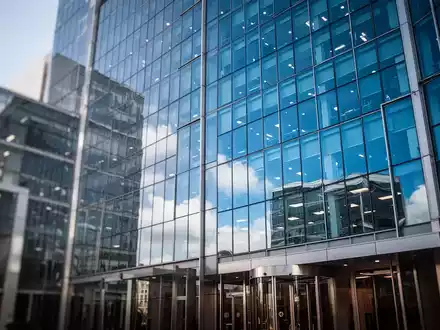Modernes Bürogebäude aus Glas vor blauem Himmel als Symbol für Konzernstrukturen und Steuerrecht. - Foto: über boerse-global.de