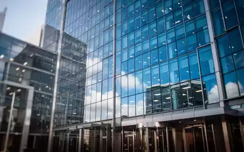 Modernes Bürogebäude aus Glas vor blauem Himmel als Symbol für Konzernstrukturen und Steuerrecht. - Foto: über boerse-global.de