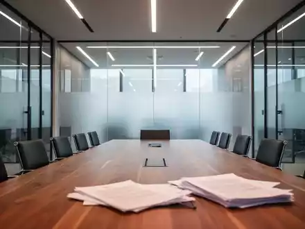 Moderner, leerer Konferenzraum mit einem großen Holztisch, symbolisch für unternehmerische Mitbestimmung. - Foto: über boerse-global.de