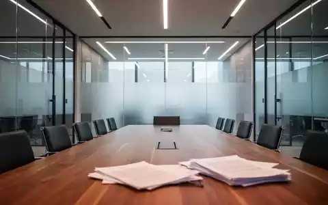 Moderner, leerer Konferenzraum mit einem großen Holztisch, symbolisch für unternehmerische Mitbestimmung. - Foto: über boerse-global.de