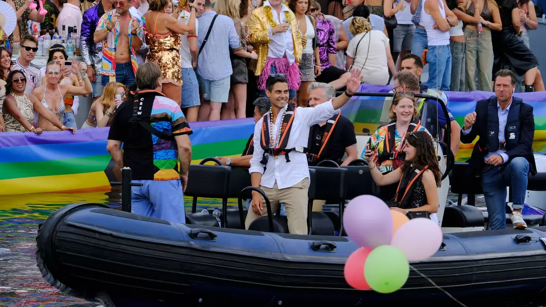 Der niederländische Ministerpräsident Rob Jetten steht auf einem Boot und winkt während der Canal Parade in Amsterdam. - Bild: Patrick Post/AP/dpa