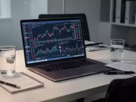 Ein moderner Schreibtisch mit Laptop, der Börsencharts anzeigt, sowie Notizen zur Finanzplanung. - Foto: über boerse-global.de