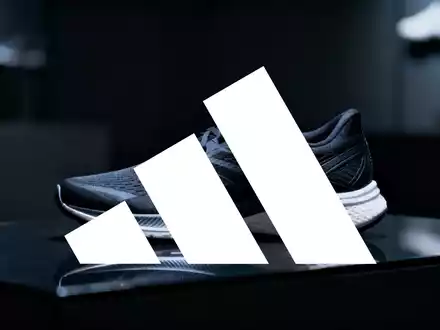 Hochwertiger Sportschuh auf einer dunklen, reflektierenden Oberfläche in einer professionellen Studio-Umgebung. - Foto: über boerse-global.de