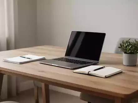 Ein minimalistisch gestalteter, aufgeräumter Schreibtisch in einem ruhigen Homeoffice mit Laptop und Notizbuch. - Foto: über boerse-global.de