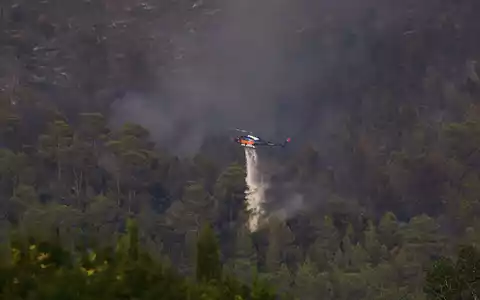 Im Süden Frankreichs waren bei einem wieder aufgeflammten Feuer mehrere Löschhubschrauber im Einsatz. - Foto: Clement Mahoudeau/AFP Pool/AP/dpa