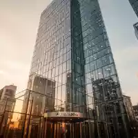 Moderne Glasfassade eines Bankhochhauses im Frankfurter Bankenviertel bei Sonnenuntergang. - Foto: über boerse-global.de