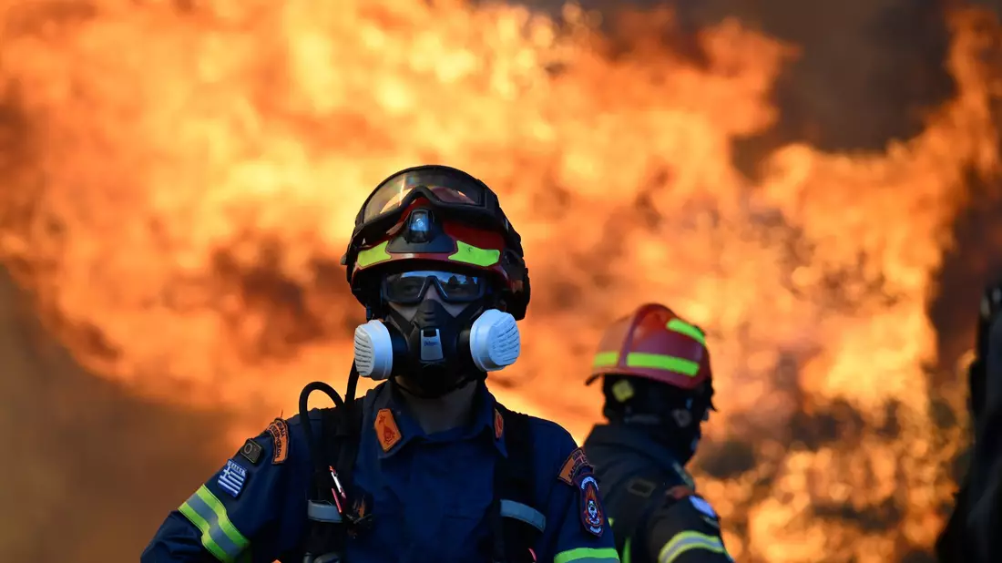 Ein Feuerwehrmann steht vor den lodernden Flammen nordwestlich von Athen. - Bild: Michael Varaklas/AP/dpa