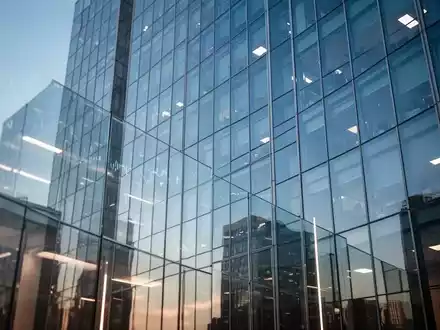 Moderne Glasfassade eines Bürogebäudes mit Reflexionen des Himmels als Symbol für Finanzthemen. - Foto: über boerse-global.de
