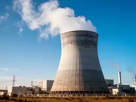 Modernes Kernkraftwerk mit Kühlturm bei klarem blauem Himmel als Symbol für den Uran-Sektor. - Foto: über boerse-global.de