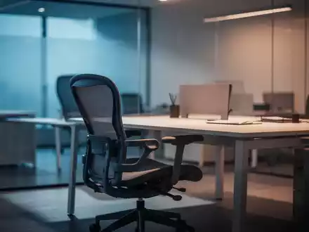 Ein minimalistischer, moderner Arbeitsplatz mit einem leeren Bürostuhl, der die psychische Belastung im Arbeitsalltag symbolisiert. - Foto: über boerse-global.de