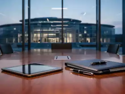 Ein moderner Konferenzraum mit einem Tablet und einer Rechtsakte vor dem unscharfen Hintergrund des EU-Gerichtsgebäudes. - Foto: über boerse-global.de