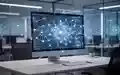 Moderner Büroarbeitsplatz mit digitalem Netzwerk-Overlay auf einem Monitor als Symbol für KI-Transparenz am Arbeitsplatz. - Foto: über boerse-global.de