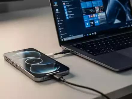 Ein iPhone neben einem Windows-Laptop, das die geräteübergreifende Zwischenablage-Synchronisierung darstellt. - Foto: über boerse-global.de