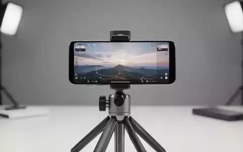 Modernes Smartphone auf Stativ mit KI-Fotobearbeitungs-Interface und Horizont-Erweiterungswerkzeugen. - Foto: über boerse-global.de