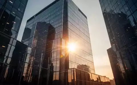 Ein modernes Bürogebäude im Sonnenaufgang als Symbol für wachsende Unternehmenssubstanz und finanzielle Stabilität. - Foto: über boerse-global.de
