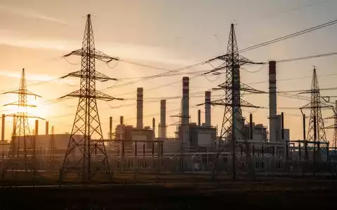 Moderne Stromerzeugungsanlagen und Strommasten bei Sonnenuntergang - Foto: über boerse-global.de