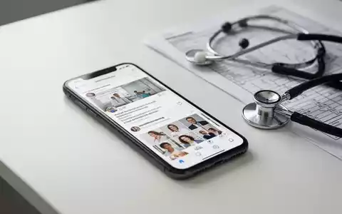 Ein Smartphone mit sozialen Medien auf einem Schreibtisch neben einem Stethoskop und medizinischen Unterlagen. - Foto: über boerse-global.de