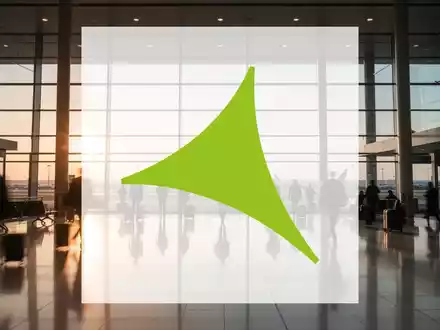 Moderner Flughafen mit weitläufiger Glasfassade und einfallendem Sonnenlicht in einer geschäftigen Atmosphäre. - Foto: über boerse-global.de