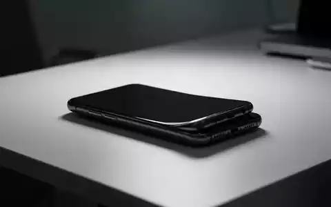 Silhouette eines modernen Smartphones auf einem minimalistischen Schreibtisch bei atmosphärischer Beleuchtung. - Foto: über boerse-global.de