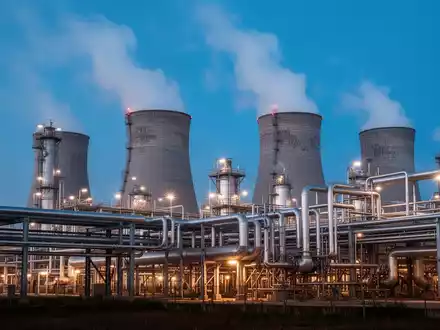 Industrielle Chemieanlage bei Dämmerung mit Kühltürmen und Rohrleitungssystemen. - Foto: über boerse-global.de