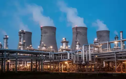 Industrielle Chemieanlage bei Dämmerung mit Kühltürmen und Rohrleitungssystemen. - Foto: über boerse-global.de