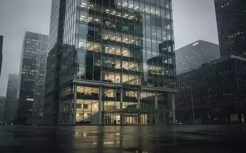 Modernes Bürogebäude an einem bewölkten Tag als Symbol für finanzielle Unsicherheit bei Immobilienunternehmen. - Foto: über boerse-global.de