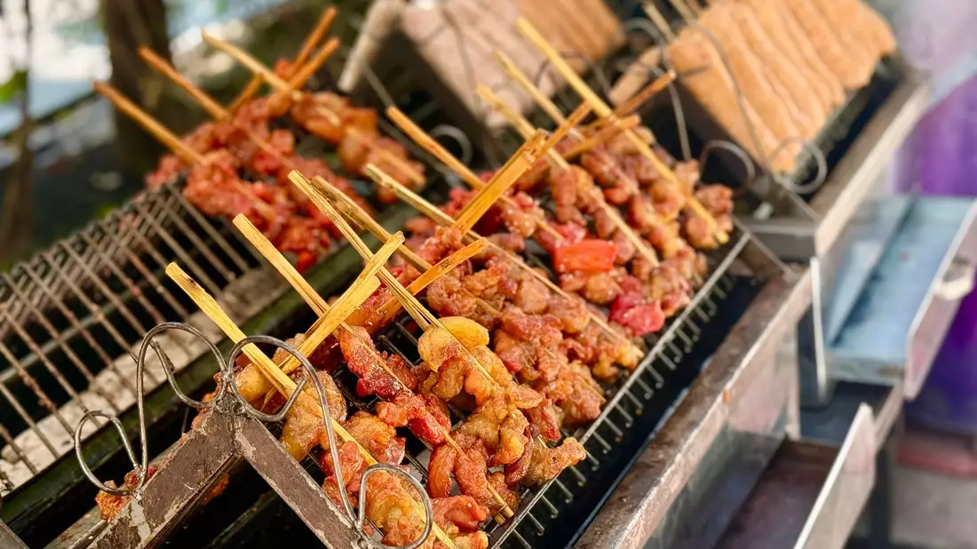 In Deutschland wäre das eher ein Mittagessen - aber die Thais lieben marinierte Schweinespieße (Moo Ping) schon zum Frühstück.  - Bild: Carola Frentzen/dpa