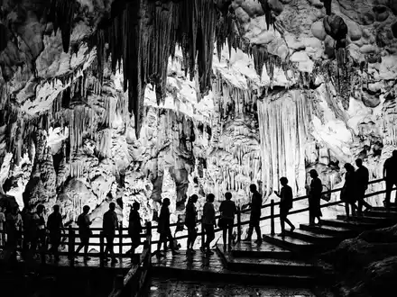 Schwarzweiss-Reportagebild vom Wahrzeichen Reed-Flute-Cave in Guilin China, dokumentarische Reisefotografie mit starken Kontrasten - Foto: THN