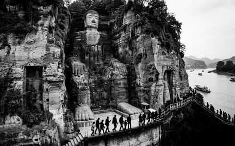 Schwarzweiss-Reportagebild vom Wahrzeichen Leshan Großer Buddha in Leshan China, dokumentarische Reisefotografie mit starken Kontrasten - Foto: THN