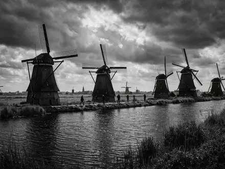 Schwarzweiss-Reportagebild vom Wahrzeichen Windmühlen von Kinderdijk in Kinderdijk Niederlande, dokumentarische Reisefotografie mit starken Kontrasten - Foto: THN