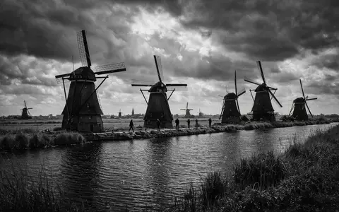 Schwarzweiss-Reportagebild vom Wahrzeichen Windmühlen von Kinderdijk in Kinderdijk Niederlande, dokumentarische Reisefotografie mit starken Kontrasten - Foto: THN