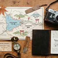 Flatlay-Reise-Arrangement rund um Ashi-See in Hakone Japan, Karte Kompass Kamera und generische Reiserequisiten - Foto: THN