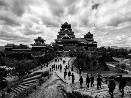 Schwarzweiss-Reportagebild vom Wahrzeichen Burg Kumamoto in Kumamoto Japan, dokumentarische Reisefotografie mit starken Kontrasten - Foto: THN