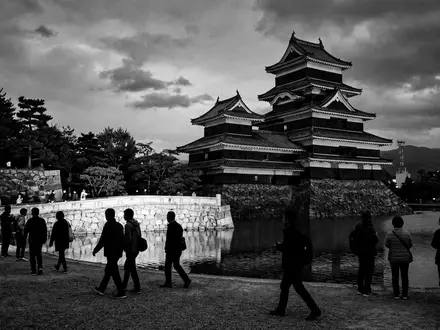 Schwarzweiss-Reportagebild vom Wahrzeichen Burg Matsumoto in Matsumoto Japan, dokumentarische Reisefotografie mit starken Kontrasten - Foto: THN