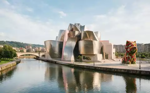 Editorialbild im Reisemagazin-Stil vom Wahrzeichen Guggenheim-Museum Bilbao in Bilbao Spanien, ausgewogene Bildgestaltung und natuerliches Umgebungslicht - Foto: THN