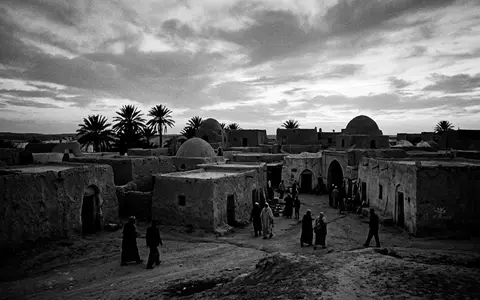 Schwarzweiss-Reportagebild vom Wahrzeichen Douz Sahara-Tor in Douz Tunesien, dokumentarische Reisefotografie mit starken Kontrasten - Foto: THN