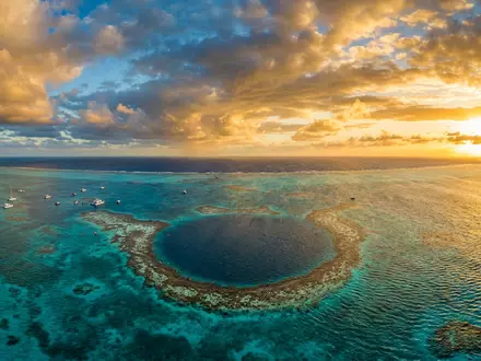 Fotorealistische Panoramaaufnahme von Great Blue Hole in Lighthouse Reef Belize, warmes Abendlicht auf Wahrzeichen - Foto: THN