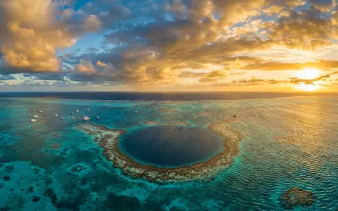 Fotorealistische Panoramaaufnahme von Great Blue Hole in Lighthouse Reef Belize, warmes Abendlicht auf Wahrzeichen - Foto: THN