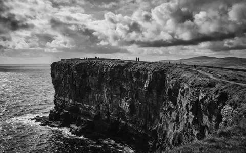 Schwarzweiss-Reportagebild vom Wahrzeichen Cliffs of Moher in Liscannor Irland, dokumentarische Reisefotografie mit starken Kontrasten - Foto: THN