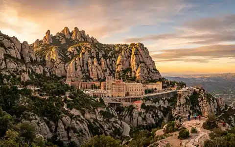 Fotorealistische Panoramaaufnahme von Kloster Montserrat in Montserrat Spanien, warmes Abendlicht auf Wahrzeichen - Foto: THN