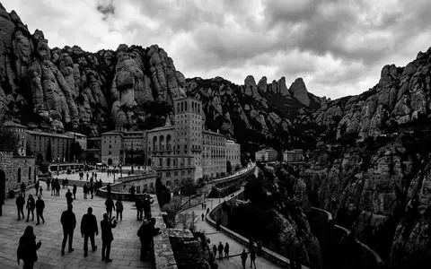 Schwarzweiss-Reportagebild vom Wahrzeichen Kloster Montserrat in Montserrat Spanien, dokumentarische Reisefotografie mit starken Kontrasten - Foto: THN