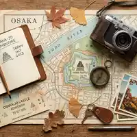 Flatlay-Reise-Arrangement rund um Burg Osaka in Osaka Japan, Karte Kompass Kamera und generische Reiserequisiten - Foto: THN